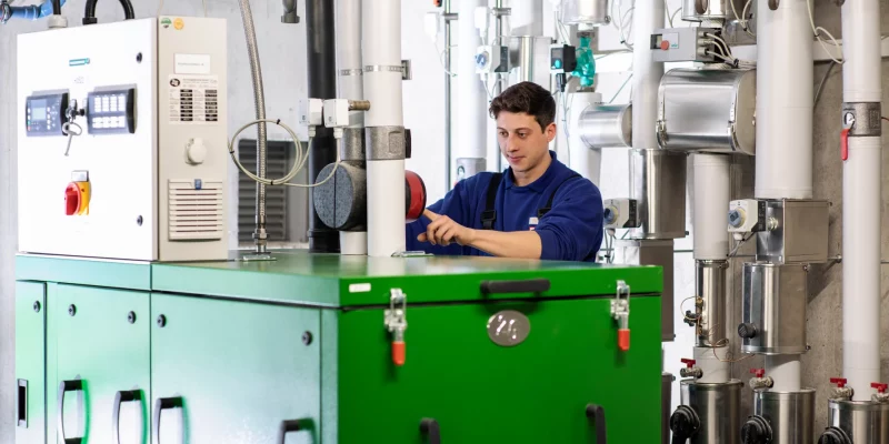 Ein Monteur überprüft die Einstellungen an einer Heizungsanlage